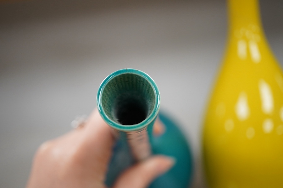 A late 19th century Japanese turquoise glazed narrow neck bottle vase, 31cm high, a smaller similar vase, 22cm high and a tall yellow glazed vase, 31cm high. Condition - repair to neck of yellow vase